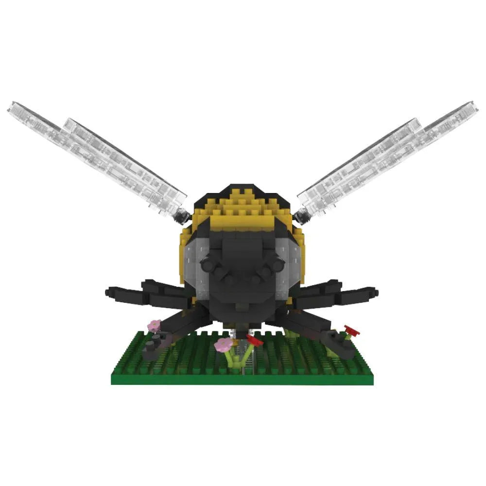 Bee mini block building set on a green plate with flowers against a white background.