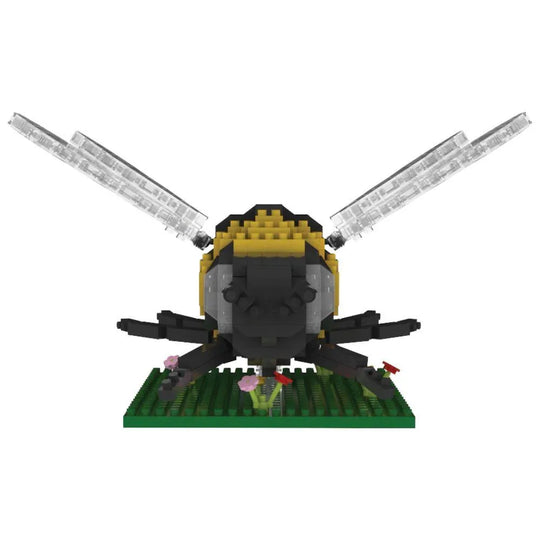 Bee mini block building set on a green plate with flowers against a white background.