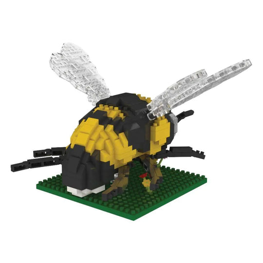 Bee mini block building set on a green plate with flowers against a white background.