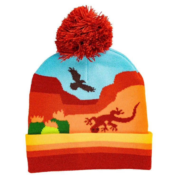 A colorful Southwest Junior Ranger Beanie cap with a pom-pom, featuring a desert landscape with mesas, cacti, a lizard, and a bird of prey.