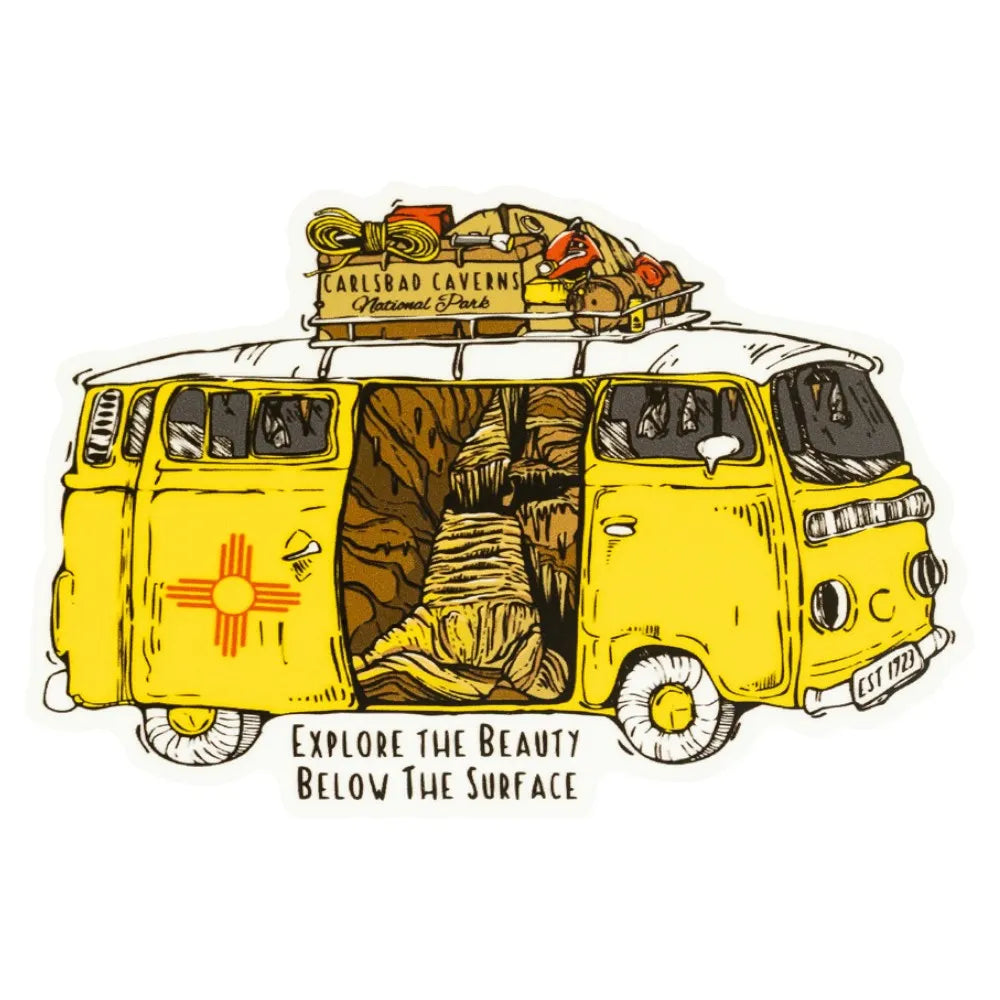 Sticker of an illustrated van with the New Mexico flag on it and an open door that shows the inside of Carlsbad Caverns National Park, loaded with luggage, on a white background.