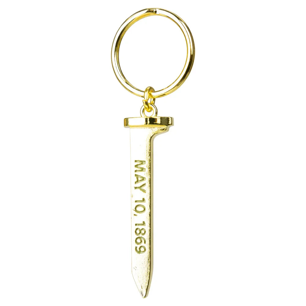 Gold colored keychain with a spike-shaped pendant displaying 'May 10, 1869' on a white background