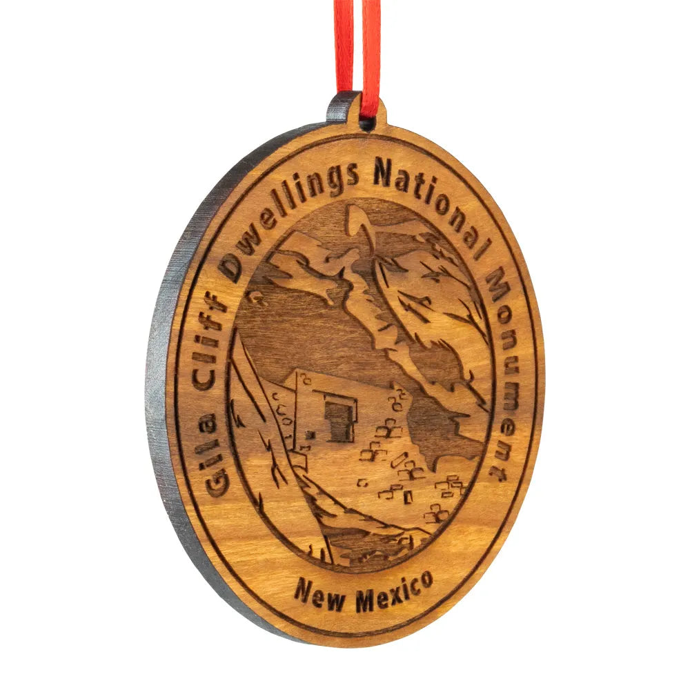 Wooden ornament with 'Gila Cliff Dwellings National Monument, New Mexico' engraving on a white background