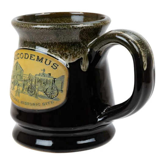 Black ceramic mug with a decorative label featuring 'Nicodemus National Historic Site' on a white background.