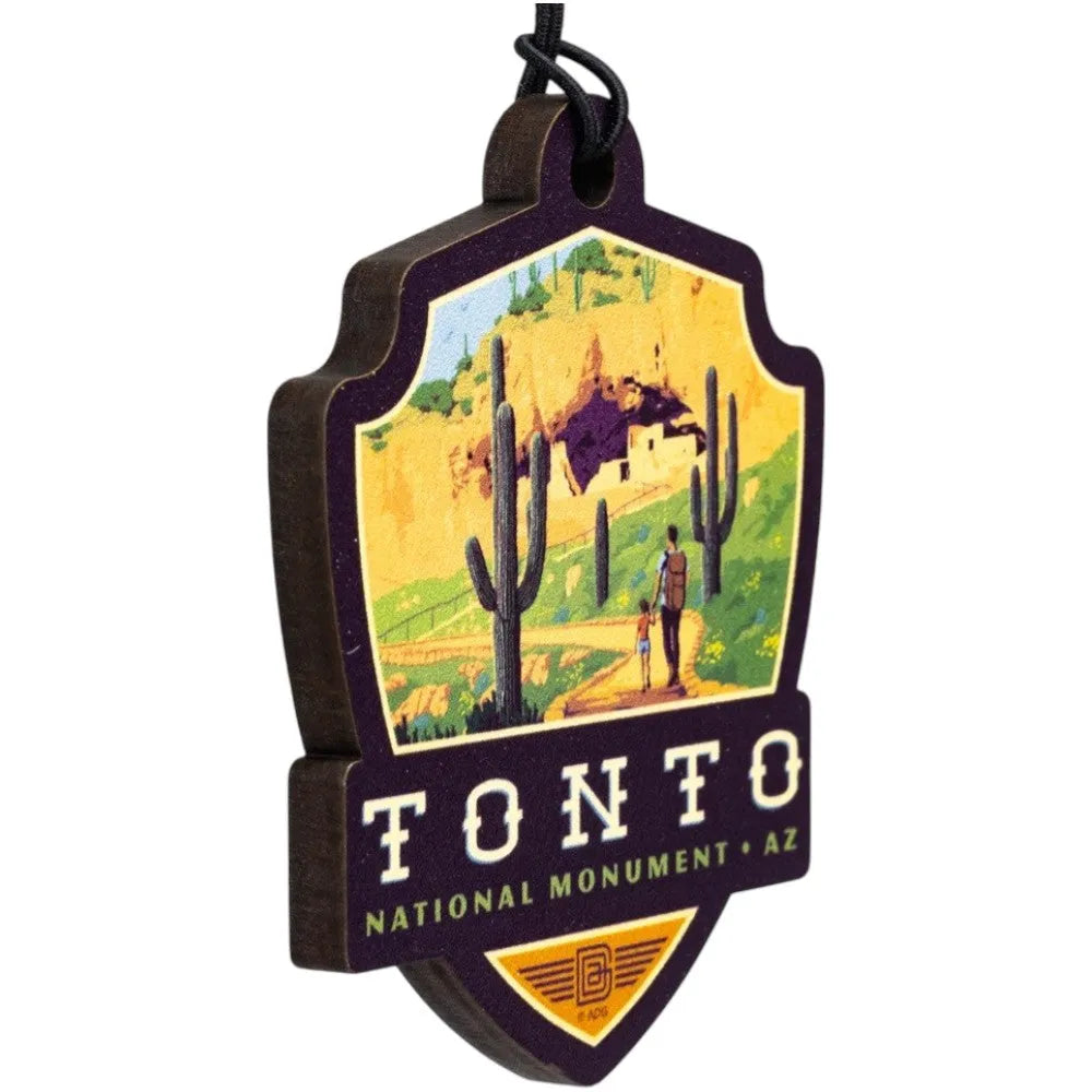 Badge-shaped ornament with Tonto National Monument design featuring a desert scene and cacti.