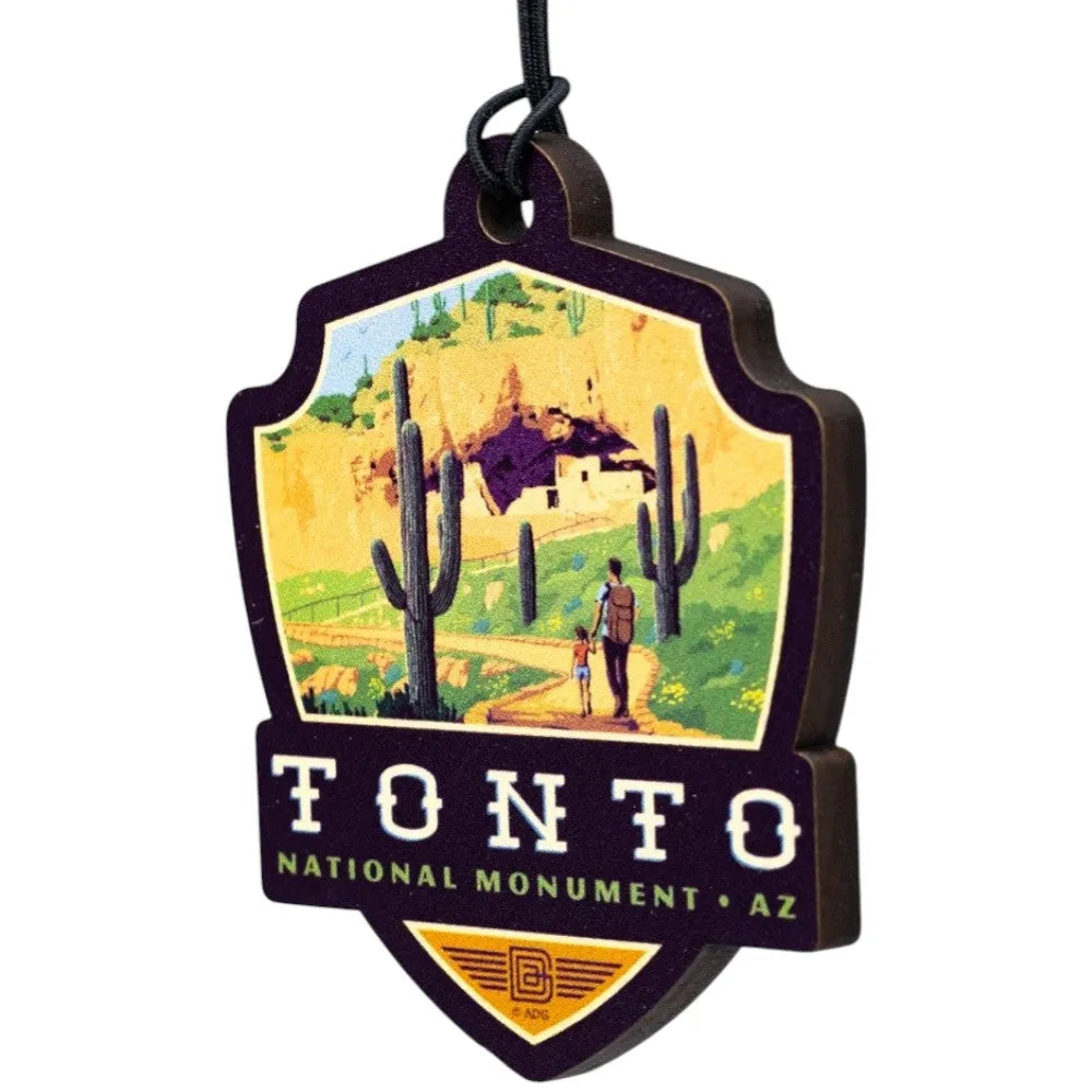 Badge-shaped ornament with Tonto National Monument design featuring a desert scene and cacti.