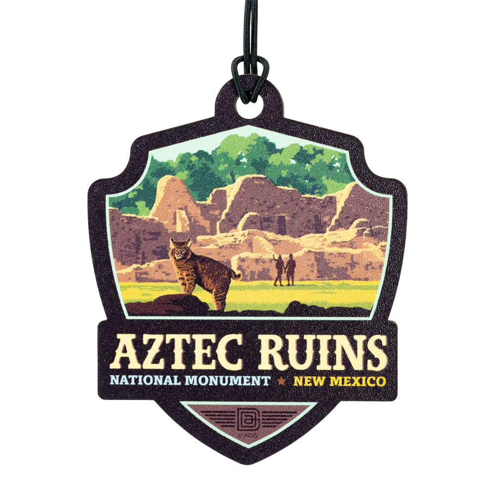 Aztec Ruins National Monument badge ornament with a bobcat and people in front of ruins