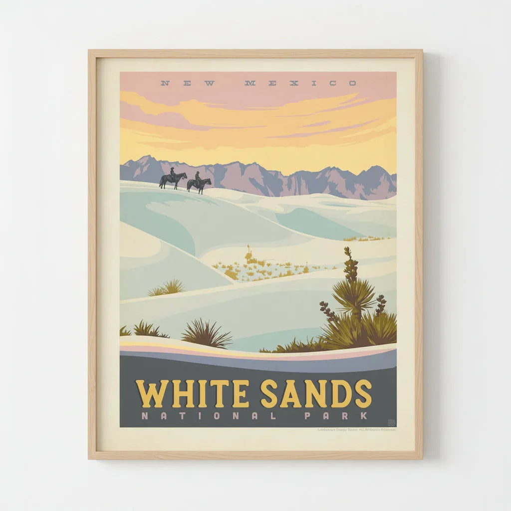 A vintage-style travel poster for White Sands National Park in New Mexico, showing pale blue-white sand dunes, distant purple mountains, and a warm yellow-orange sky, framed and mounted on a wall.