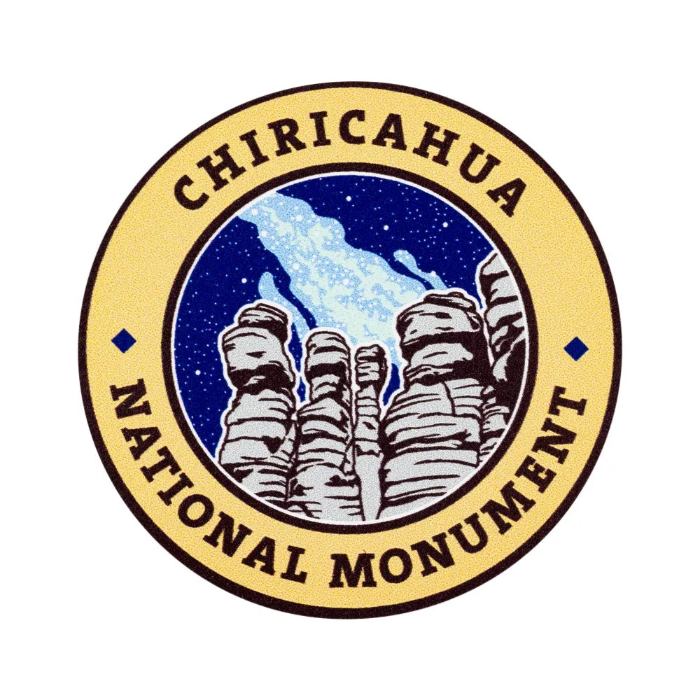 A circular sticker for Chiricahua National Monument, featuring a tan outer ring with dark brown text and a central illustration of rock formations under a deep blue starry sky.