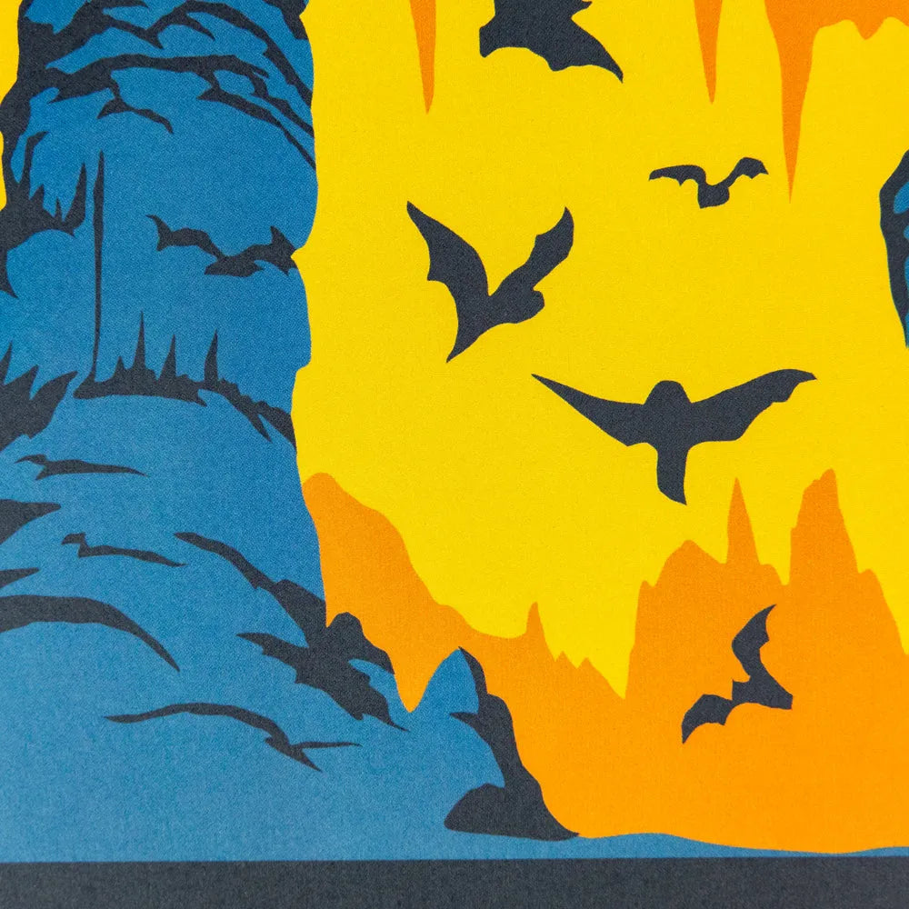 A graphic art print featuring a stylized scene of bats flying in front of a blue cave formation.
