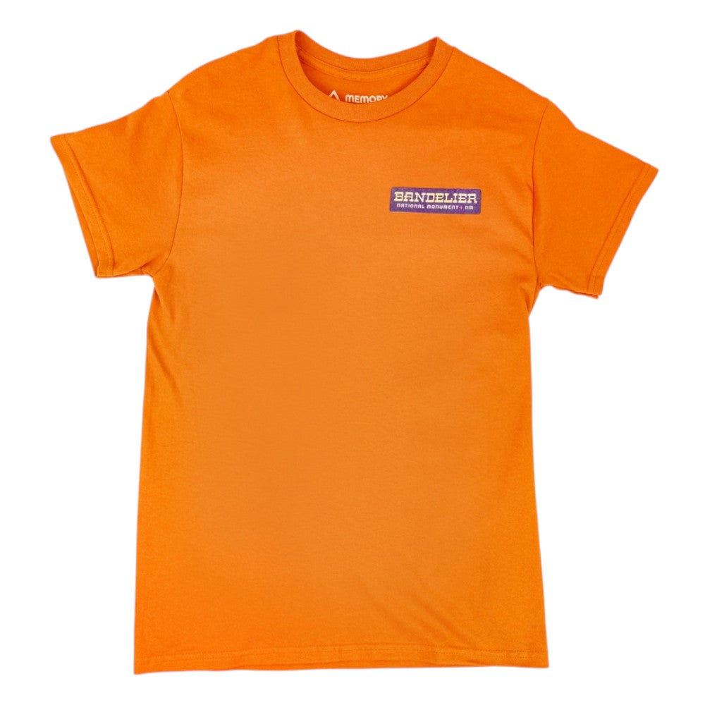 Orange t-shirt with a small logo for Bandelier National Monument in the upper left chest on a white background