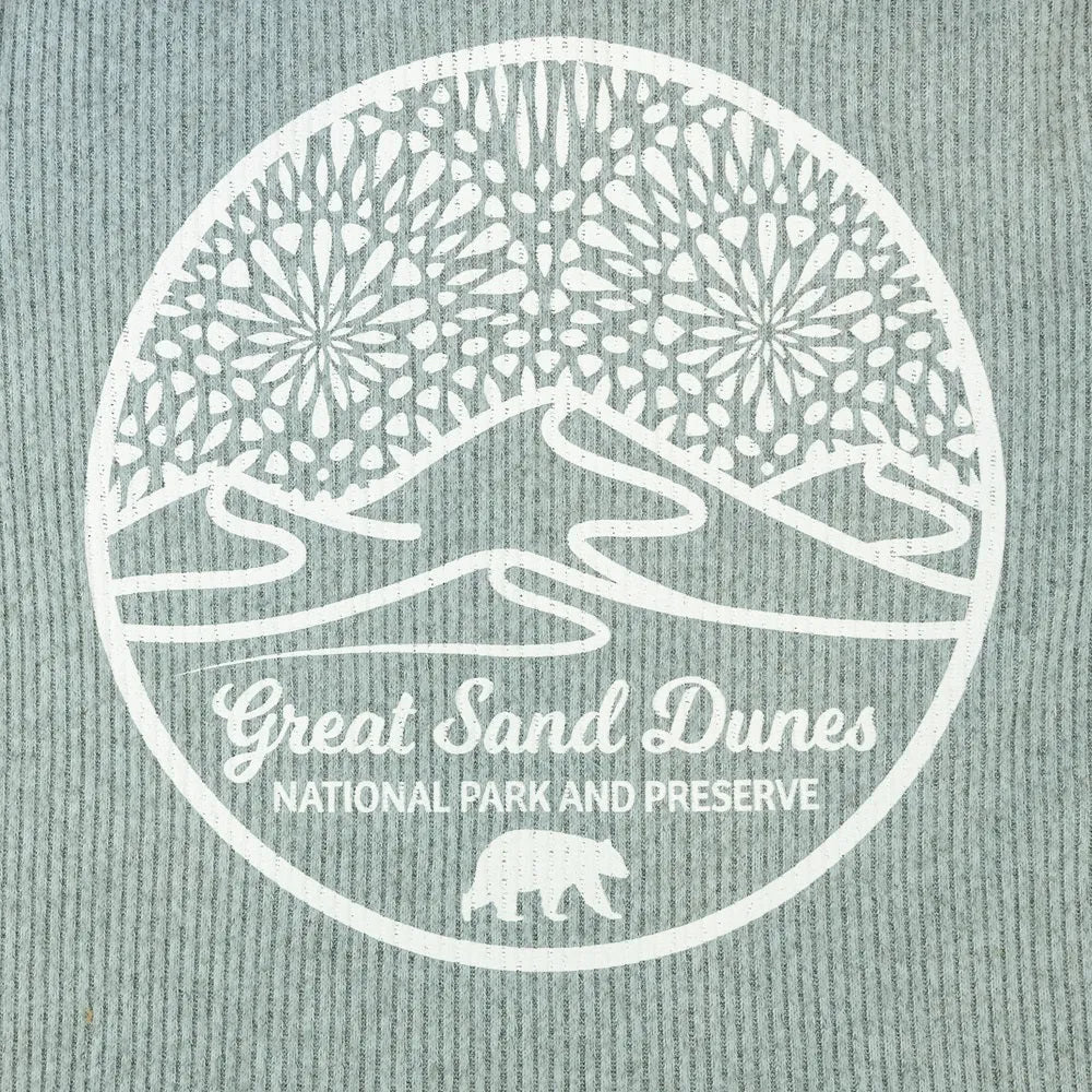 Logo closeup of Great Sand Dunes National Park and Preserve on a textured fabric background