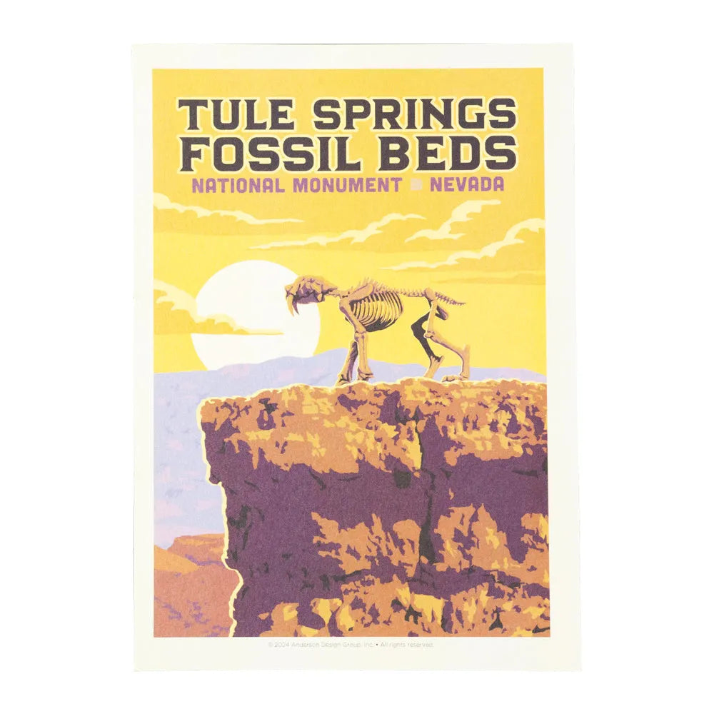 Post card of Tule Springs Fossil Beds National Monument in Nevada with a saber-toothed tiger skeleton on a cliff.