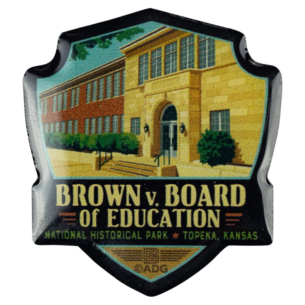 Badge shaped pin with illustration of a school building and text about Brown v. Board of Education National Historical Park.