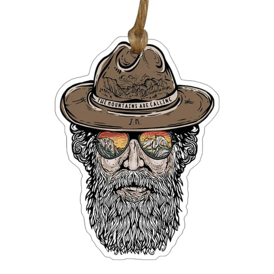 Ornament with a design of a bearded man wearing a hat and sunglasses with 'The mountains are calling' text on the hat.