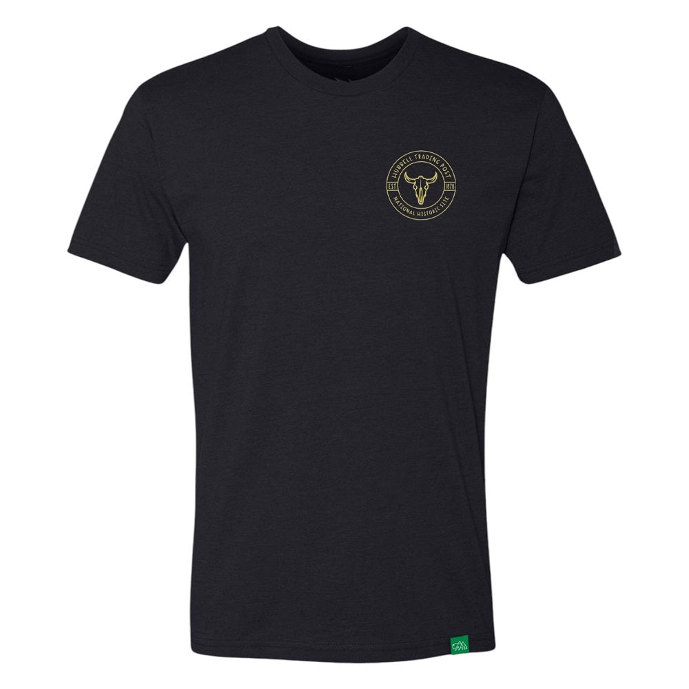 Black t-shirt with a horned cow skeleton logo on the chest against a white background and text 'Hubbell Trading Post National Historic Site' around it