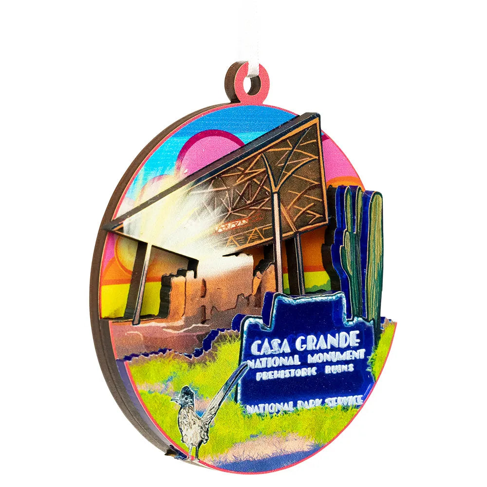 Colorful wooden ornament of Casa Grande National Monument with a blue sign.
