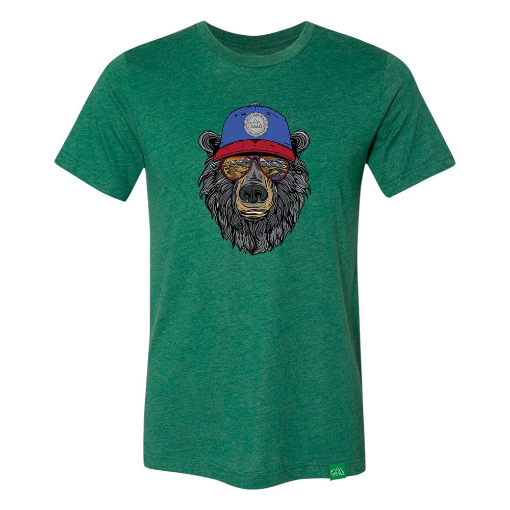 Green t-shirt with a bear graphic wearing a blue cap that has 'Great Sand Dunes National Park & Preserve' on it and sunglasses with a scenic landscape reflected in them on a white background