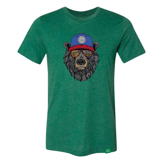 Green t-shirt with a bear graphic wearing a blue cap that has 'Great Sand Dunes National Park & Preserve' on it and sunglasses with a scenic landscape reflected in them on a white background