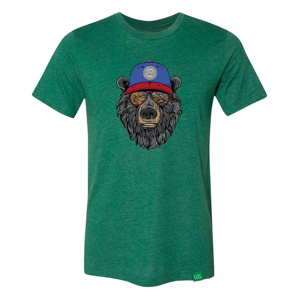 Green t-shirt with a bear graphic wearing a blue cap that has 'Great Sand Dunes National Park & Preserve' on it and sunglasses with a scenic landscape reflected in them on a white background
