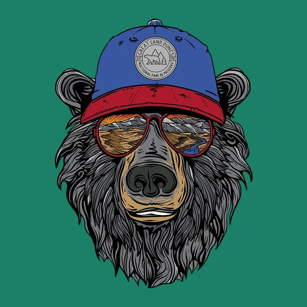 Illustration of a bear wearing a blue and red cap featuring text 'Great Sand Dunes National Park & Preserve' and sunglasses with a landscape reflected in them on a green background