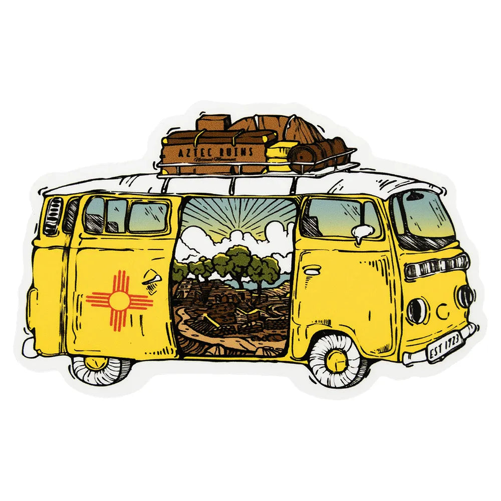 Illustration of a van with the New Mexico flag on the side paneling and a scenic view of Aztec Ruins National Monument through the open door and luggage on a white background