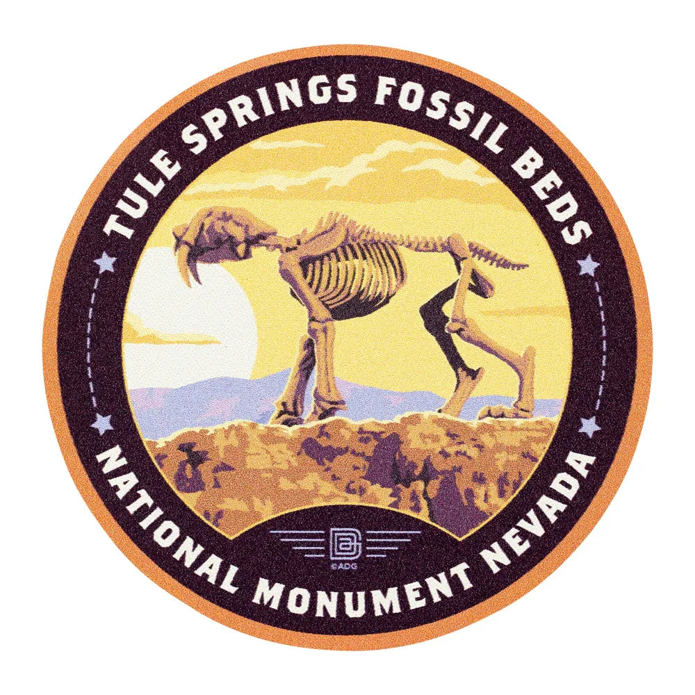 Circular logo for Tule Springs Fossil Beds National Monument, Nevada featuring a saber-toothed tiger skeleton.