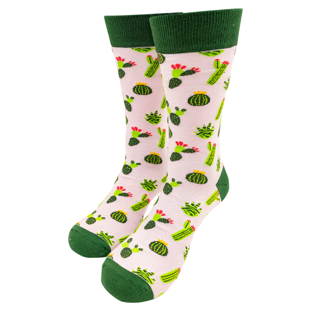 Pair of knit socks with green cuffs, heels, and toes featuring a cactus design on pink background set against a white background