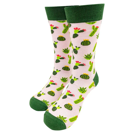 Pair of knit socks with green cuffs, heels, and toes featuring a cactus design on pink background set against a white background