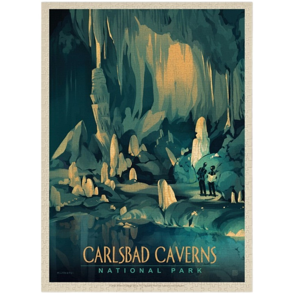 A completed vintage-style puzzle for Carlsbad Caverns National Park, showing an illustrated cave interior with stalactites and stalagmites in teal, dark blue, and warm beige tones. Two small figures stand near the cave entrance at the lower right.