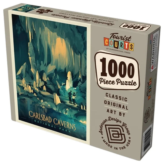 A 1000-piece jigsaw puzzle box featuring Carlsbad Caverns National Park art by Anderson Design Group. The box displays a vintage-style illustration of a cave interior in teal, blue, and yellow tones, alongside product details on a light gray background.