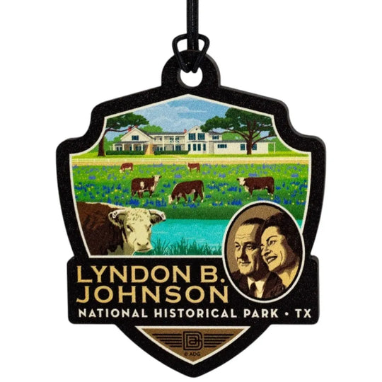 Badge-shaped ornament with Lyndon B. Johnson National Historical Park design featuring a farm scene and portraits.