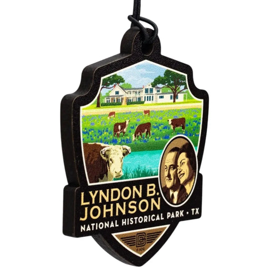 Badge-shaped ornament with Lyndon B. Johnson National Historical Park design featuring a farm scene and portraits.