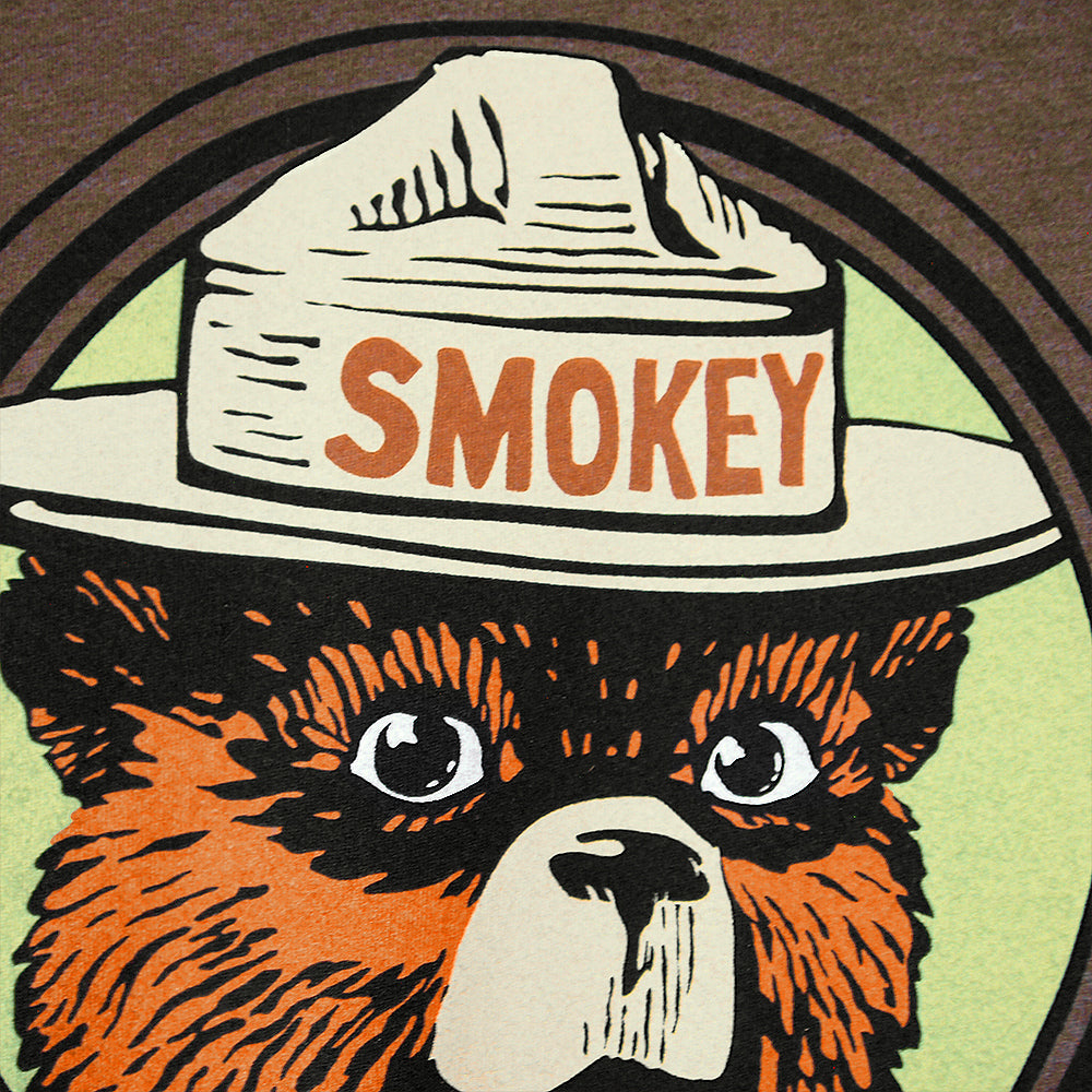 Illustration of a bear wearing a hat with 'Smokey' on it, on a circular background.