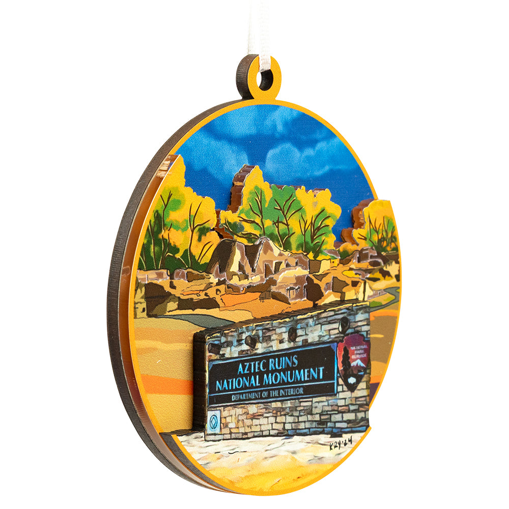 Decorative ornament of Aztec Ruins National Monument with desert landscape and ruins.