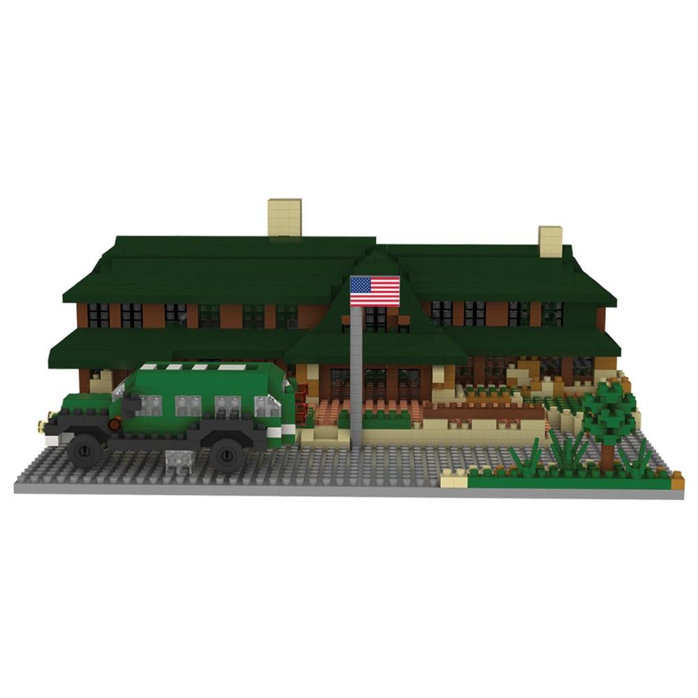 Min block set of the Lodge at Bryce Canyon National Park with a green roof and a flag, featuring a toy car in front on a white background.