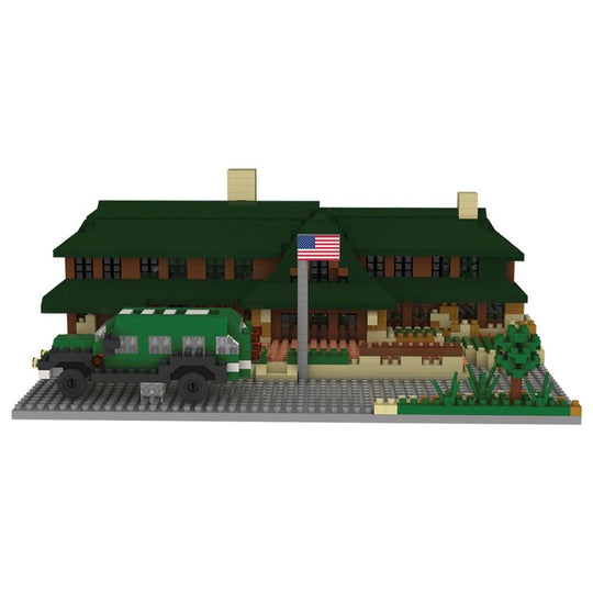 Min block set of the Lodge at Bryce Canyon National Park with a green roof and a flag, featuring a toy car in front on a white background.