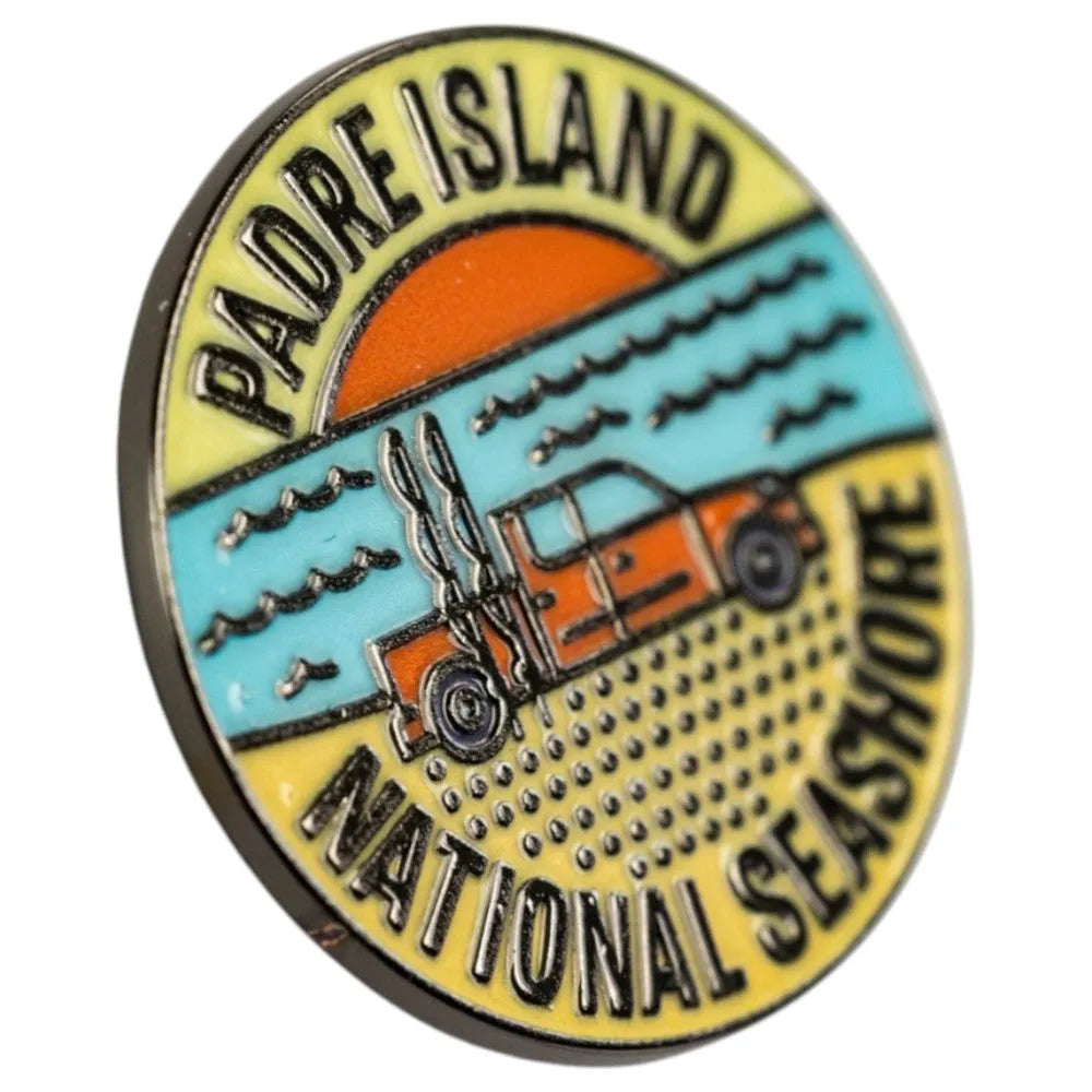 Round pin with Padre Island National Seashore design featuring a car and sunset.
