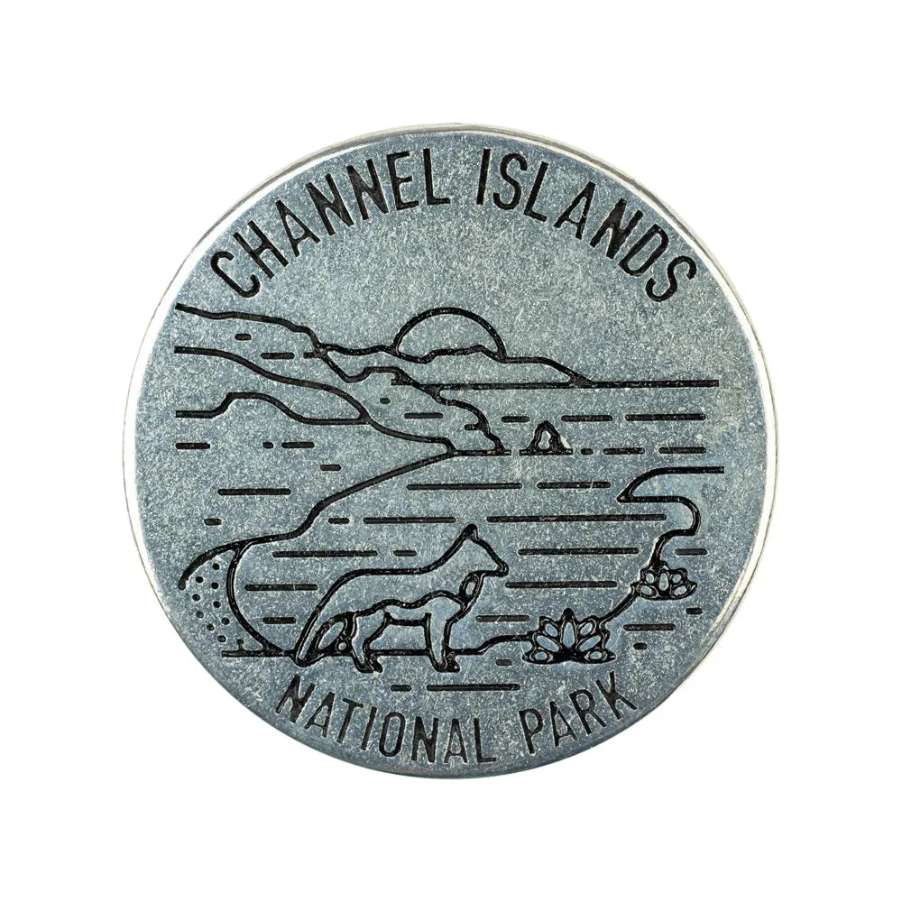 A round silver-toned metal token engraved with a landscape scene and the words 'CHANNEL ISLANDS NATIONAL PARK,' shown on a plain white background.