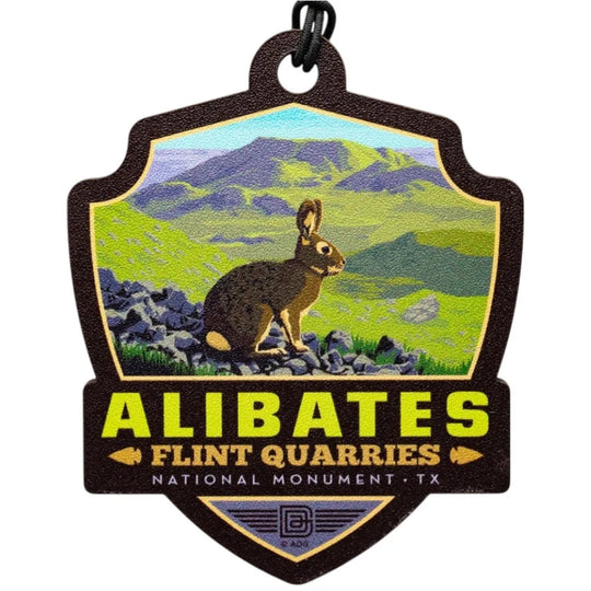 Badge shaped ornament of Alibates Flint Quarries National Monument with a rabbit and mountain landscape.