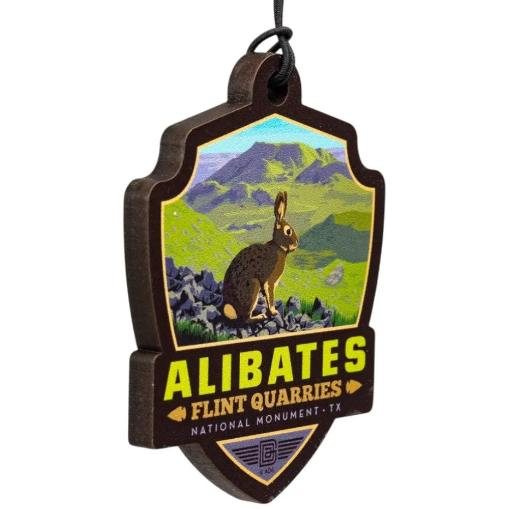 Badge shaped ornament of Alibates Flint Quarries National Monument with a rabbit and mountain landscape.