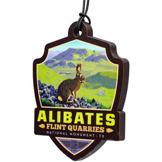 Badge shaped ornament of Alibates Flint Quarries National Monument with a rabbit and mountain landscape.
