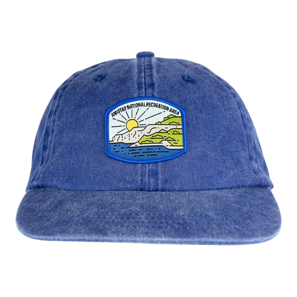 Blue denim cap with a scenic patch on a white background