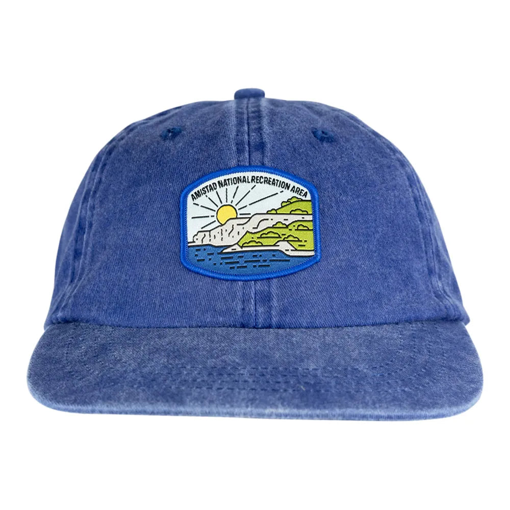 Blue denim cap with a scenic patch on a white background