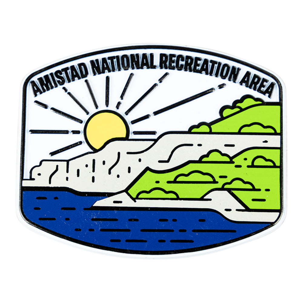 Magnet featuring a logo of Amistad National Recreation Area with a sun, mountains, and water.