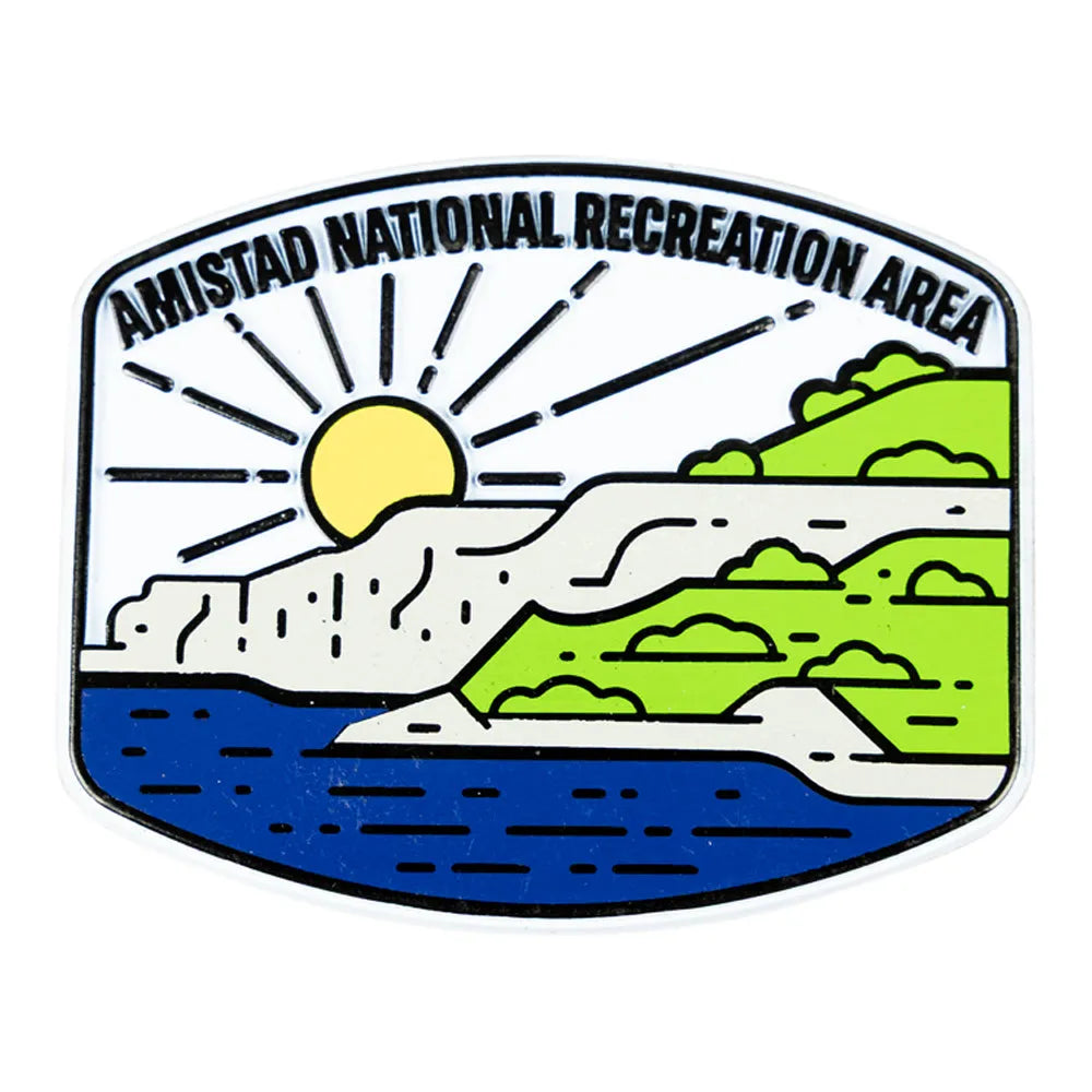 Magnet featuring a logo of Amistad National Recreation Area with a sun, mountains, and water.