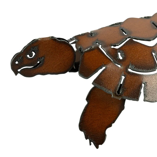 Brown patina metal turtle-shaped accessory on a white background