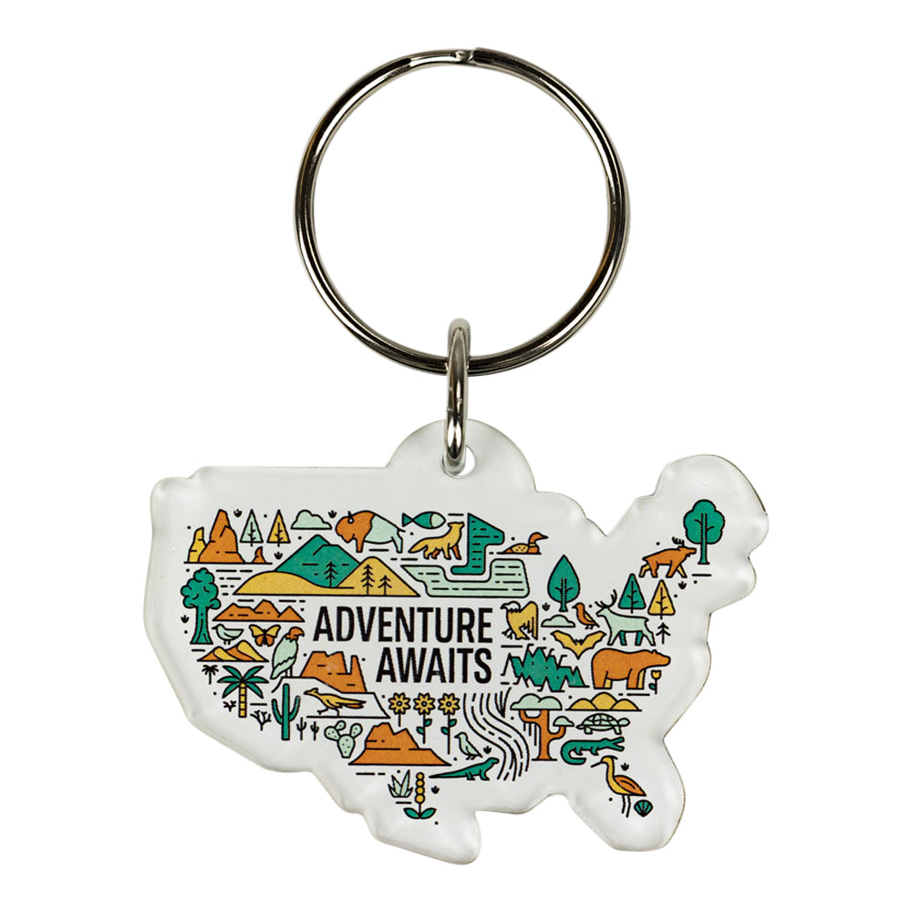 Keychain shaped like a map of the United States with nature-themed illustrations and 'Adventure Awaits' text.
