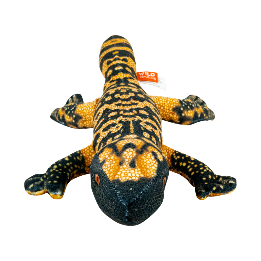 A plush lizard toy with a black and yellow spotted pattern, featuring a small orange tag that reads 'WILD'.