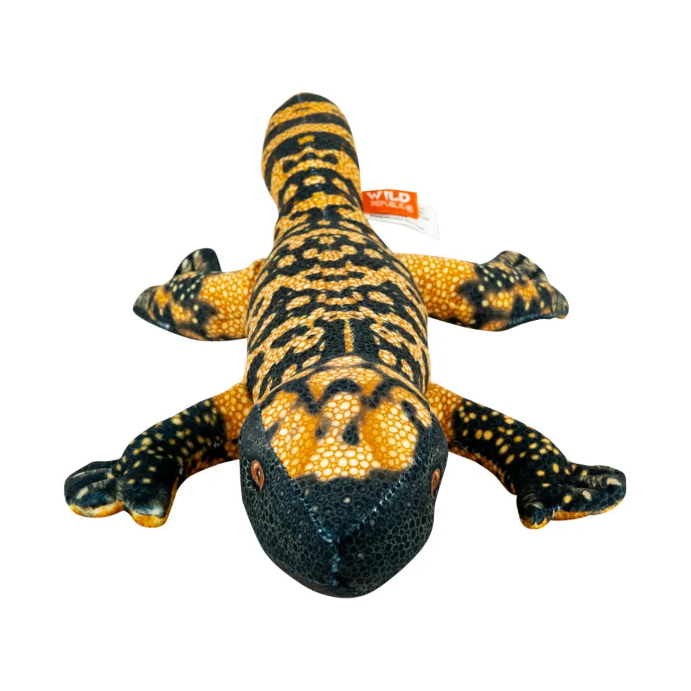 A plush lizard toy with a black and yellow spotted pattern, featuring a small orange tag that reads 'WILD'.